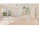 Bright living room featuring tile flooring, ceiling fan, and large windows that offer ample natural light at 1002 Kelsey Ave, Oviedo, FL 32765