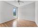 Well-lit bedroom with light wood floors, ceiling fan, and a window overlooking the yard at 10176 Hart Branch Cir, Orlando, FL 32832