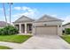 Tan home with a well-manicured lawn and two-car garage provides great curb appeal at 10176 Hart Branch Cir, Orlando, FL 32832