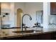 Close-up of a kitchen sink with granite countertops and an elegant faucet with open concept living space at 10176 Hart Branch Cir, Orlando, FL 32832