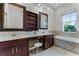 Main bathroom featuring double sinks, a large mirror, and a standalone tub at 10176 Hart Branch Cir, Orlando, FL 32832