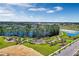 Aerial view of a community park featuring playground, dog park, walking paths, and lush landscaping around a pond at 13532 Autumn Harvest Ave, Winter Garden, FL 34787