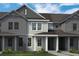 Townhome with light-colored siding, dark-gray trim, and a covered entrance framed by white pillars at 13532 Autumn Harvest Ave, Winter Garden, FL 34787