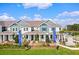 A beautiful two-story townhouse with blue accents, a covered porch, and professionally landscaped grounds at 13532 Autumn Harvest Ave, Winter Garden, FL 34787