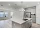 Open-concept kitchen with stainless steel appliances, center island, and neutral tones in a modern style at 13532 Autumn Harvest Ave, Winter Garden, FL 34787