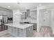 Modern kitchen with an island, stainless steel appliances, stylish pendant lighting and grey cabinetry at 13532 Autumn Harvest Ave, Winter Garden, FL 34787