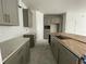 Unfinished kitchen with gray cabinets, granite countertops, an island, and white backsplash at 13532 Autumn Harvest Ave, Winter Garden, FL 34787