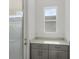 Well-lit laundry room boasts gray cabinets, light countertops, and a window over the workspace at 13532 Autumn Harvest Ave, Winter Garden, FL 34787