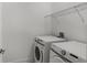 Modern laundry room with white washer and dryer and wire shelving above appliances at 13532 Autumn Harvest Ave, Winter Garden, FL 34787
