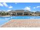 View of the community pool and the pool house with tables and chairs under the shaded pavilion at 13532 Autumn Harvest Ave, Winter Garden, FL 34787