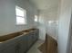 Unfinished bathroom featuring gray cabinets, tile flooring, and windows to provide natural light at 13817 Luna Harvest Ave, Winter Garden, FL 34787
