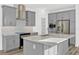 Modern kitchen with gray cabinets, stainless steel appliances, granite countertops, and a stylish backsplash at 13817 Luna Harvest Ave, Winter Garden, FL 34787