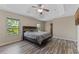 Spacious bedroom featuring a ceiling fan, wood-look flooring, and natural light from the windows at 13832 Dove Wing Ct, Orlando, FL 32828