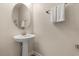 Bright half bathroom with pedestal sink, rounded mirror and towel rack. Clean and functional at 1395 Olympic Club Blvd, Champions Gate, FL 33896