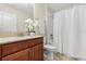Bathroom featuring granite countertop with dark wood cabinetry and a shower/tub with a curtain at 1395 Olympic Club Blvd, Champions Gate, FL 33896