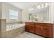 Elegant bathroom featuring a soaking tub, double vanity, and large mirror at 1395 Olympic Club Blvd, Champions Gate, FL 33896