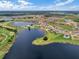 An aerial view shows a beautiful lakeside community with multiple ponds, manicured lawns, and lush landscaping at 15149 Canoe Pl, Winter Garden, FL 34787