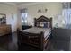 Elegant bedroom with a dark wood, ornate bed frame, matching dressers and dark hardwood flooring at 15149 Canoe Pl, Winter Garden, FL 34787