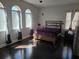 Sunlit bedroom featuring hardwood floors, large windows, and a comfortable bed with a plush purple cover at 15149 Canoe Pl, Winter Garden, FL 34787