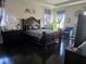 Luxurious bedroom featuring a dark, ornate bed, elegant decor, and dark hardwood flooring at 15149 Canoe Pl, Winter Garden, FL 34787