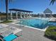 Community pool with water features, lounge chairs, and a covered pergola providing a luxurious poolside experience at 15149 Canoe Pl, Winter Garden, FL 34787