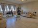 Spacious living room with tiled floors, comfortable seating, and large windows with patterned curtains at 15149 Canoe Pl, Winter Garden, FL 34787