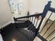 Stylish staircase with black and white risers, black wrought iron railings, and artwork adorning the walls at 15149 Canoe Pl, Winter Garden, FL 34787