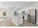Open kitchen features stainless appliances, quartz counters and an island with pendant lights at 16745 Sw 29Th Terrace, Ocala, FL 34473
