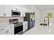 Bright kitchen boasts stainless steel appliances, white cabinets and a quartz countertop at 16745 Sw 29Th Terrace, Ocala, FL 34473