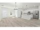 Open-concept living area featuring stainless steel appliances, kitchen island, stylish lighting, and durable flooring at 16745 Sw 29Th Terrace, Ocala, FL 34473