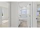 Bright bathroom featuring a shower-tub combo, marble tiling, and modern fixtures and wood-look flooring at 16753 Sw 29Th Terrace, Ocala, FL 34473