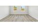 A spacious bedroom with wood-look floors and two large windows filling the room with natural light at 16753 Sw 29Th Terrace, Ocala, FL 34473
