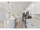 Spacious kitchen with stainless steel appliances, white cabinets, a center island, and a view to the living area at 16753 Sw 29Th Terrace, Ocala, FL 34473