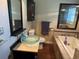 Well-lit bathroom featuring a jacuzzi tub, glass bowl sink and wood-look floors at 191 Caldwell St, Apopka, FL 32712