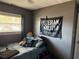 Small bedroom with one window and a dark gray accent wall with decorative military banner at 191 Caldwell St, Apopka, FL 32712