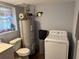 Bathroom and utility room featuring a toilet, vanity, hot water heater, and washer/dryer at 191 Caldwell St, Apopka, FL 32712