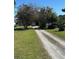 Gravel driveway leading to a home with grassy yard and mature trees at 1933 Bayview Dr, New Smyrna Beach, FL 32168