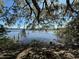 A tranquil waterfront view with gentle ripples, framed by lush foliage and the remnants of a wooden pier at 1933 Bayview Dr, New Smyrna Beach, FL 32168