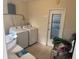 Bright laundry room with a white washer and dryer next to a door to the outside at 2108 Wolf Rd, Orlando, FL 32808