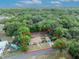 Aerial view of a cozy home nestled in a wooded neighborhood, featuring a large lot and a detached garage at 225 N Phippen Ave, Deland, FL 32724