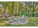 Backyard firepit sitting area with adirondack chairs and playground in natural setting at 225 N Phippen Ave, Deland, FL 32724