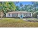 Lovely single-story home with manicured lawn, tidy shrubbery, and an inviting blue front door at 225 N Phippen Ave, Deland, FL 32724