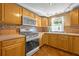 Functional kitchen featuring stainless steel appliances, warm wood cabinets and lots of natural light at 225 N Phippen Ave, Deland, FL 32724