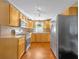 Well-lit kitchen featuring stainless steel appliances, wooden cabinets, and warm wood floors at 225 N Phippen Ave, Deland, FL 32724