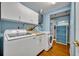 Well-equipped laundry room with modern washer and dryer, storage cabinets, and hardwood flooring at 225 N Phippen Ave, Deland, FL 32724