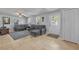 Bright and airy living room featuring tile floors, a comfortable gray sectional sofa, and lots of natural light at 225 N Phippen Ave, Deland, FL 32724