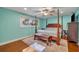 Light and airy main bedroom with wood floors, aqua walls, ceiling fan and sitting bench at 225 N Phippen Ave, Deland, FL 32724