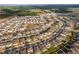 An aerial view showcasing a suburban neighborhood with houses, landscape elements, roads and a school at 2290 Sw Raven Ridge Rd, Clermont, FL 34715