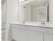 Bathroom featuring double sink vanity, and a large mirror reflecting a door at 2290 Sw Raven Ridge Rd, Clermont, FL 34715