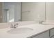Bathroom featuring a granite countertop, double sink, and large mirror reflecting the door at 2290 Sw Raven Ridge Rd, Clermont, FL 34715